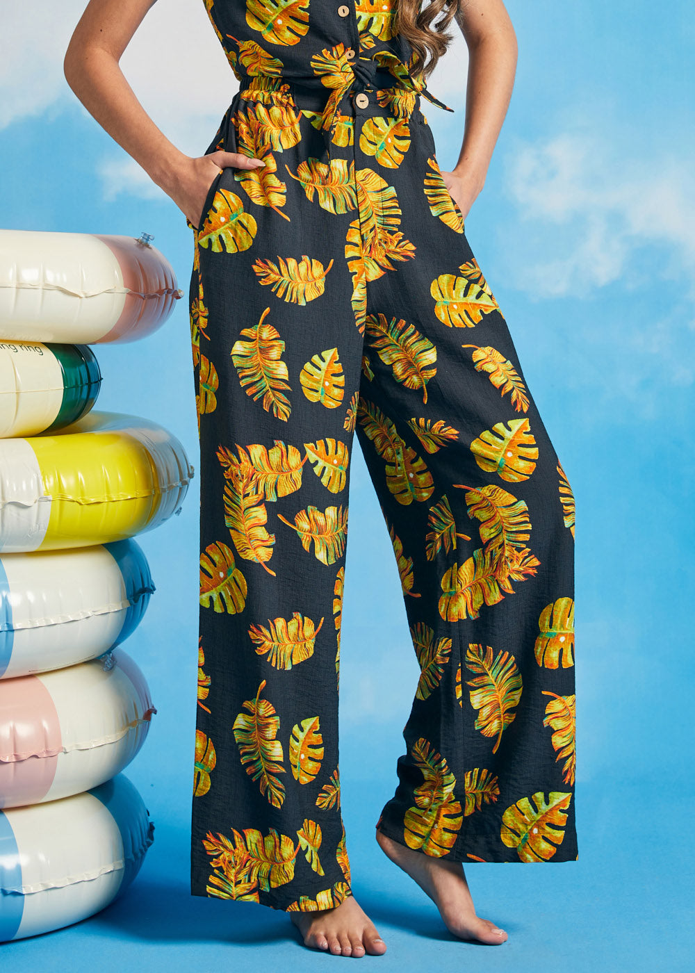 Woman posing in vintage-inspired tropical palazzo pants with pockets