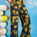 Woman posing in vintage-inspired tropical palazzo pants with pockets