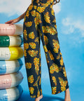 Woman wearing noir tropical palazzo pants with oversized leaf print and pockets