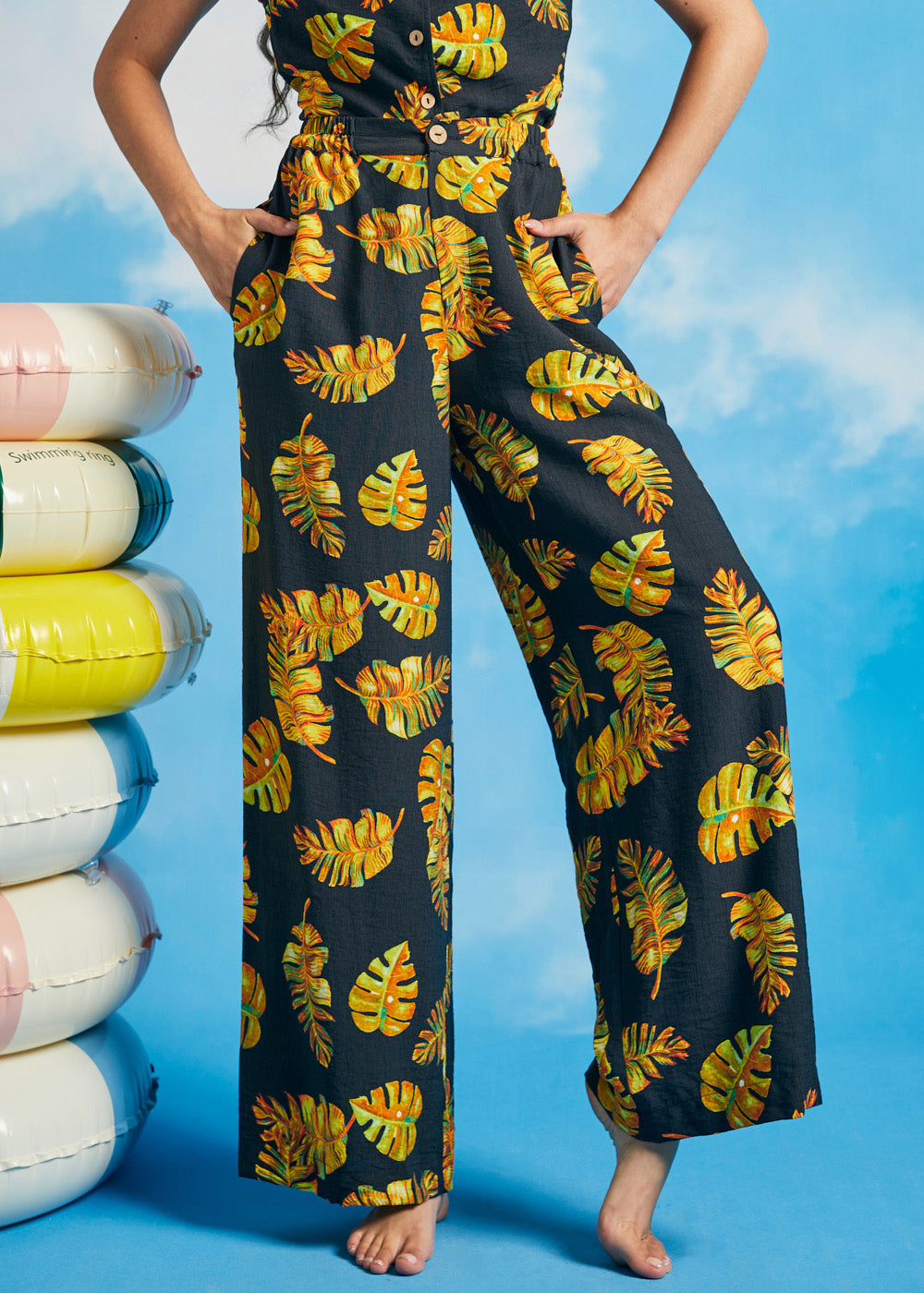 Woman wearing tropical leaf print palazzo pants with cropped wide-leg silhouette