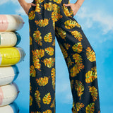 Woman wearing tropical leaf print palazzo pants with cropped wide-leg silhouette