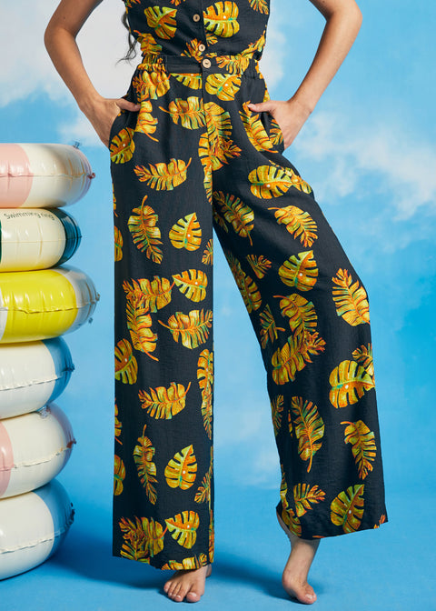 Woman wearing tropical leaf print palazzo pants with cropped wide-leg silhouette