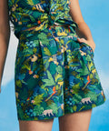 Woman wearing tropical jungle print high-waisted shorts with matching sleeveless tie-front top