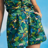 Woman wearing tropical jungle print high-waisted shorts with matching sleeveless tie-front top