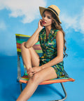 Woman sitting in beach chair wearing high-waisted jungle print shorts and matching top