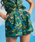 Person wearing a tropical patterned outfit against a blue sky.