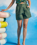 Woman posing in olive green utility shorts with relaxed fit and front pockets