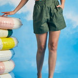 Woman posing in olive green utility shorts with relaxed fit and front pockets