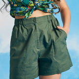Woman wearing olive green linen blend utility shorts with tropical print crop top