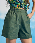 Close-up of front closure and oversized patch pockets on green shorts