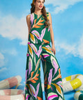 Woman wearing a colorful leaf-patterned top with matching wide leg pants