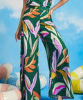 Woman posing in abstract tropical print palazzo pants with wide flowing legs