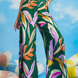 Woman posing in abstract tropical print palazzo pants with wide flowing legs