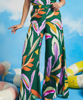 Woman wearing oversized tropical print palazzo pants with breezy resort-inspired silhouette