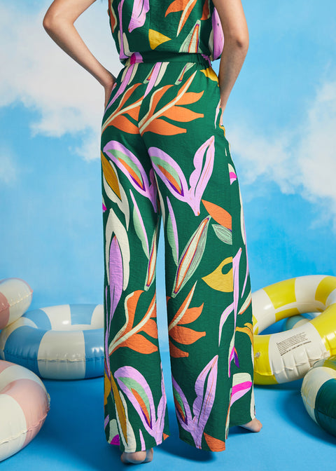 Side view of extra-wide tropical print palazzo pants with fluid drape