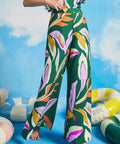 Woman wearing a colorful floral outfit with pool floats in the background