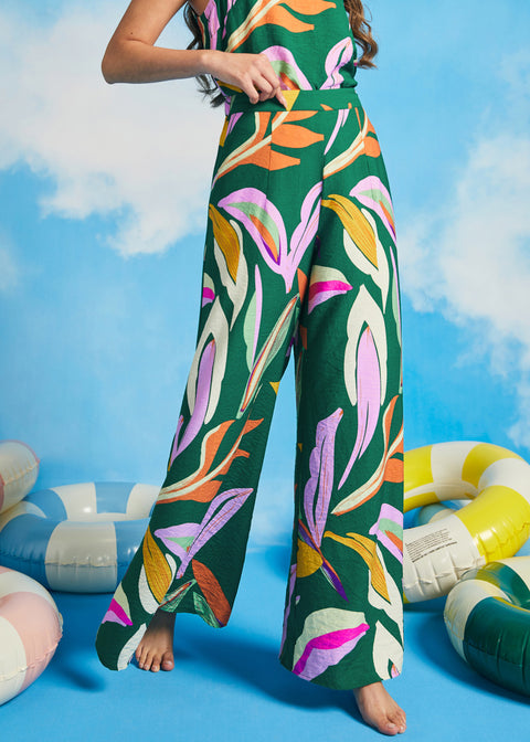 Woman wearing a colorful floral outfit with pool floats in the background