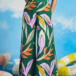 Woman modeling colorful wide-leg palazzo pants with relaxed vacation-ready styling