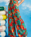 Woman wearing red tropical wide-leg pants with monstera leaf print