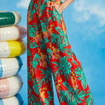Woman wearing red tropical wide-leg pants with monstera leaf print