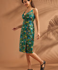Woman modeling a tropical cotton midi dress with faux-wrap bodice and adjustable straps.