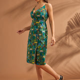 Woman modeling a tropical cotton midi dress with faux-wrap bodice and adjustable straps.