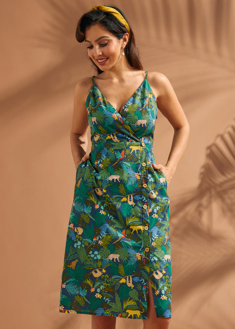 Woman wearing a cotton safari print dress with pockets and colorful rainforest motif.