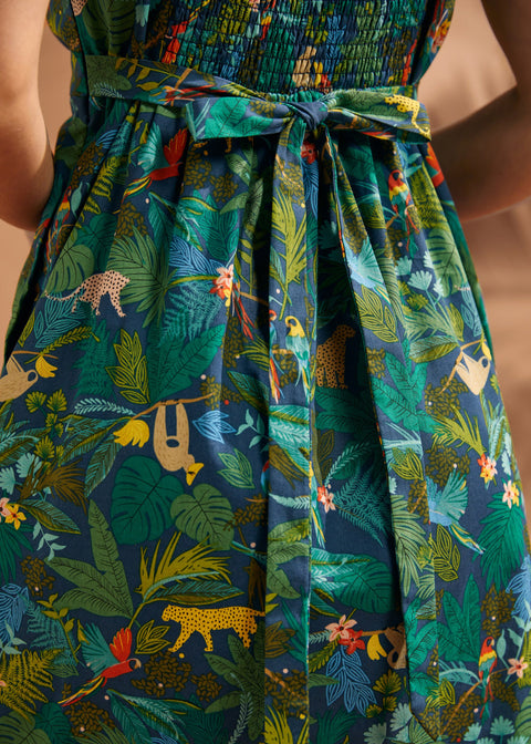 Close-up of the smocked back and tie detail on the tropical print dress.