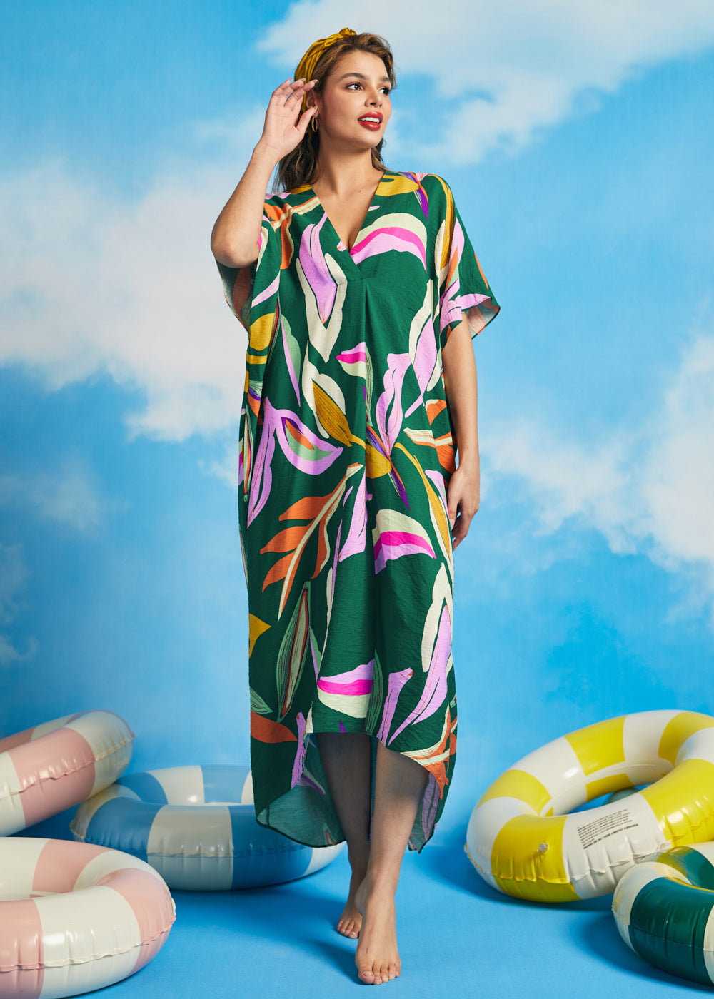 Woman wearing retro tropical caftan maxi dress with colorful abstract palm print
