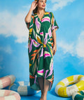 Woman wearing retro tropical caftan maxi dress with colorful abstract palm print