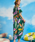 Back view of relaxed green caftan maxi dress with oversized tropical leaf print