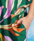 Close-up of side pocket detail on green tropical print caftan dress