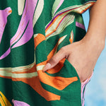 Close-up of side pocket detail on green tropical print caftan dress