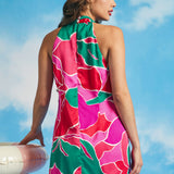 Back view of pink tropical floral mini dress with halter neckline and relaxed silhouette