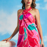 Close-up of tropical floral print and twisted neckline detail on satin-like mini dress