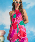Woman wearing tropical floral shift dress with halter neckline and vintage-inspired resort styling