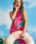 Woman posing with pastel pool float while wearing retro tropical floral mini dress