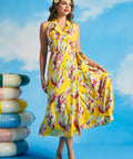 Woman holding skirt of yellow tropical leaf print wrap midi dress with pockets