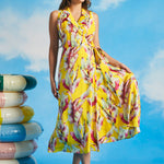 Woman holding skirt of yellow tropical leaf print wrap midi dress with pockets