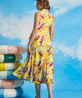 Back view of tropical yellow midi dress with sleeveless silhouette and flowing hem