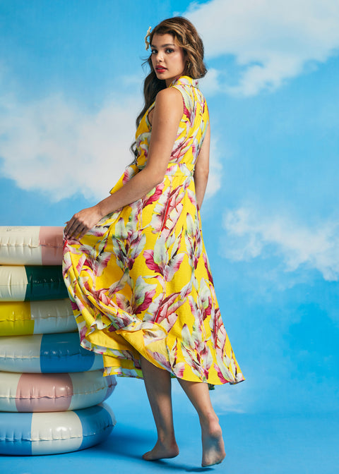 Back view of yellow tropical leaf print sleeveless midi dress with flowing skirt