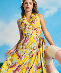 Woman posing in vintage-inspired yellow tropical midi dress with sleeveless wrap bodice