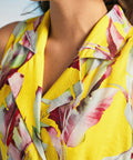 Close-up of notched collar neckline on yellow tropical print wrap dress