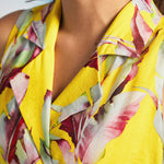 Close-up of notched collar neckline on yellow tropical print wrap dress
