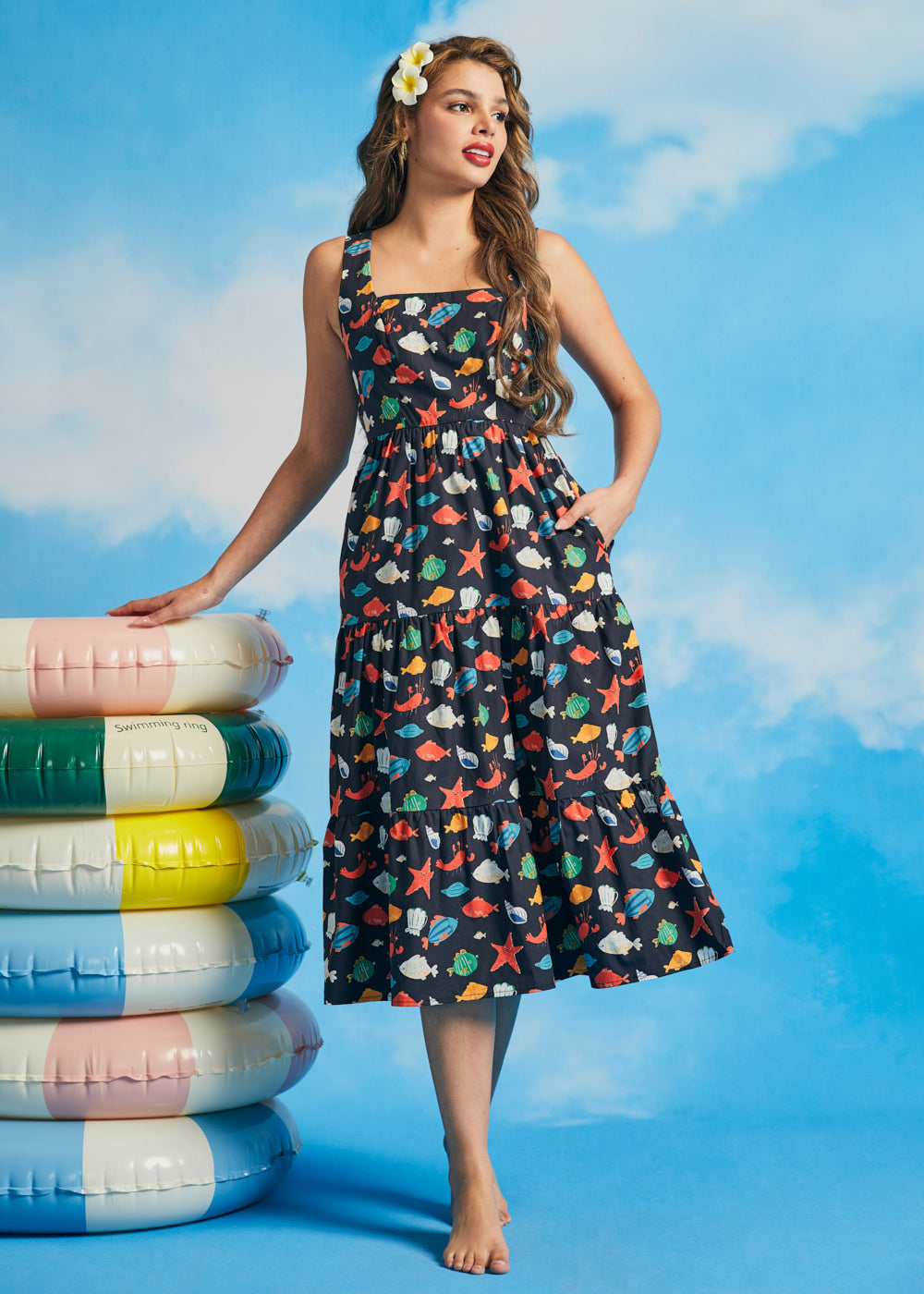 Woman wearing vintage-inspired ocean print midi dress with square neckline and tiered silhouette
