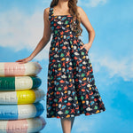 Woman wearing vintage-inspired ocean print midi dress with square neckline and tiered silhouette