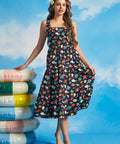 Woman wearing retro-inspired navy cotton midi dress with tiered skirt and ocean-themed print