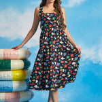 Woman wearing retro-inspired navy cotton midi dress with tiered skirt and ocean-themed print