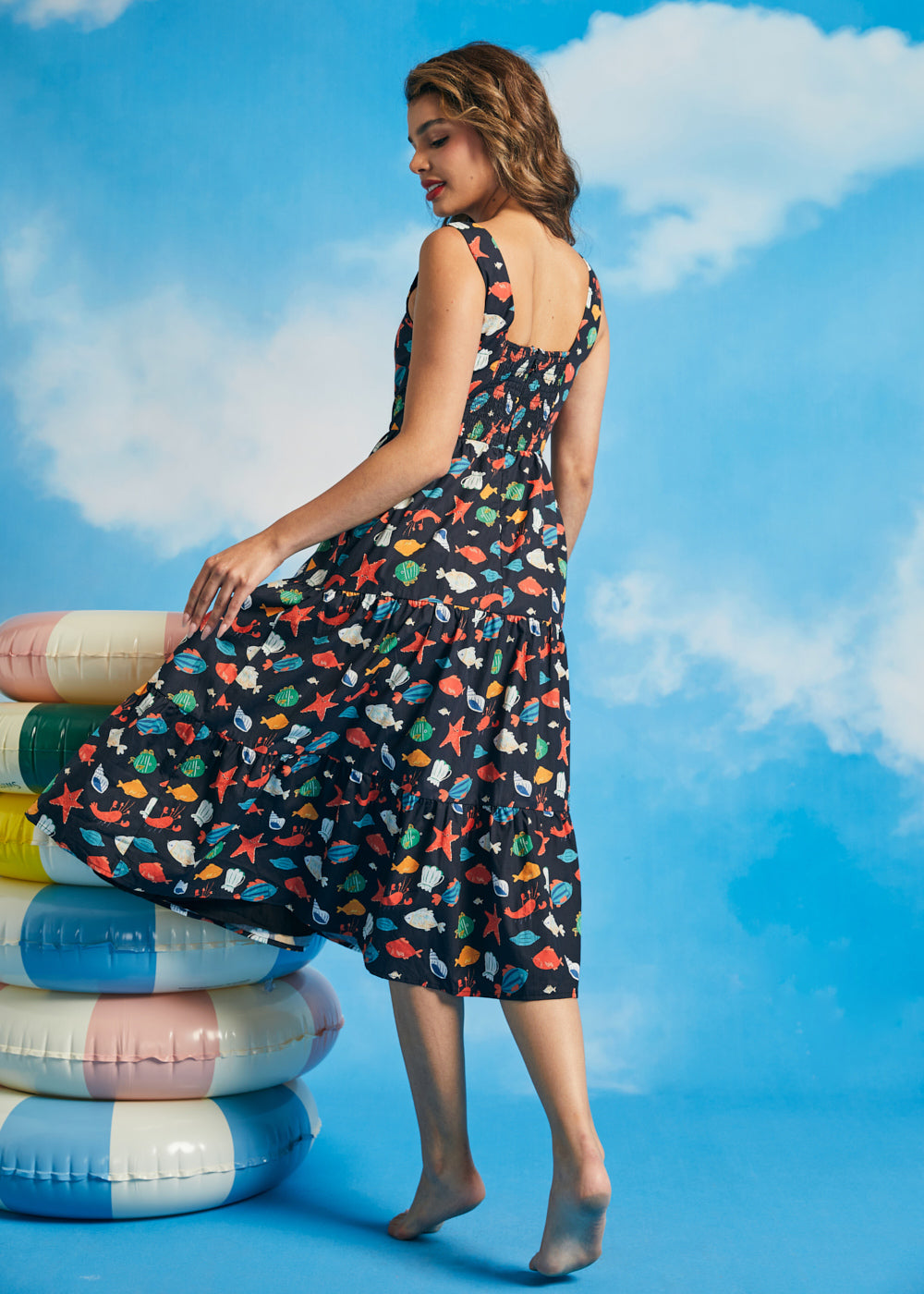 Side view of navy cotton fit-and-flare dress with tiered skirt and whimsical fish print