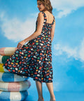 Side view of navy cotton fit-and-flare dress with tiered skirt and whimsical fish print